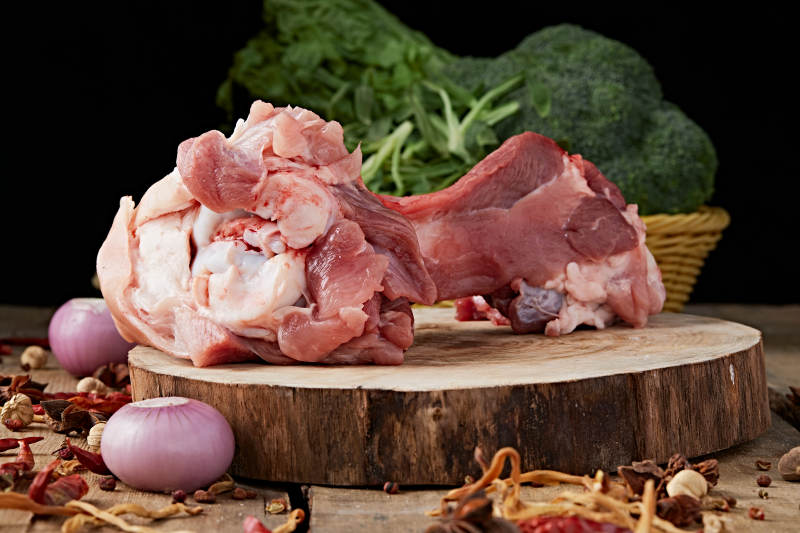 白色背景下的生鲜猪棒骨图片