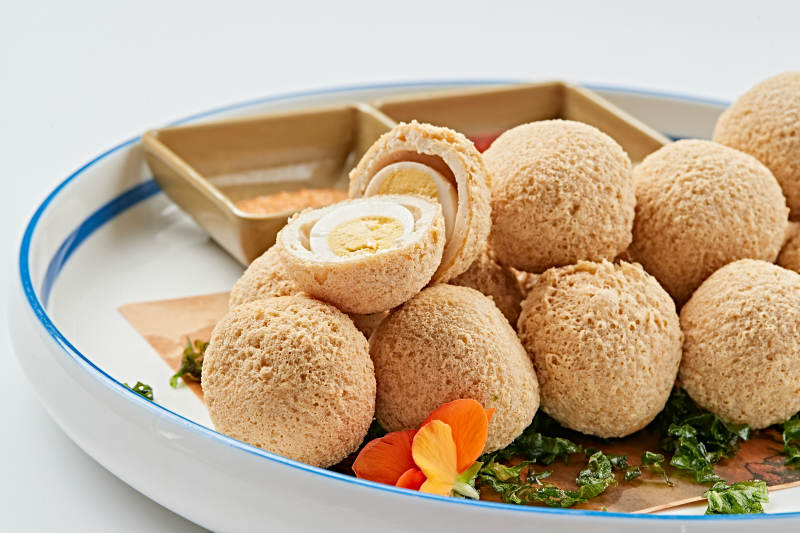 白色瓷盘装的油炸豆腐鹌鹑蛋丸子图片