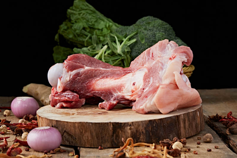 白色背景下的生鲜猪棒骨图片