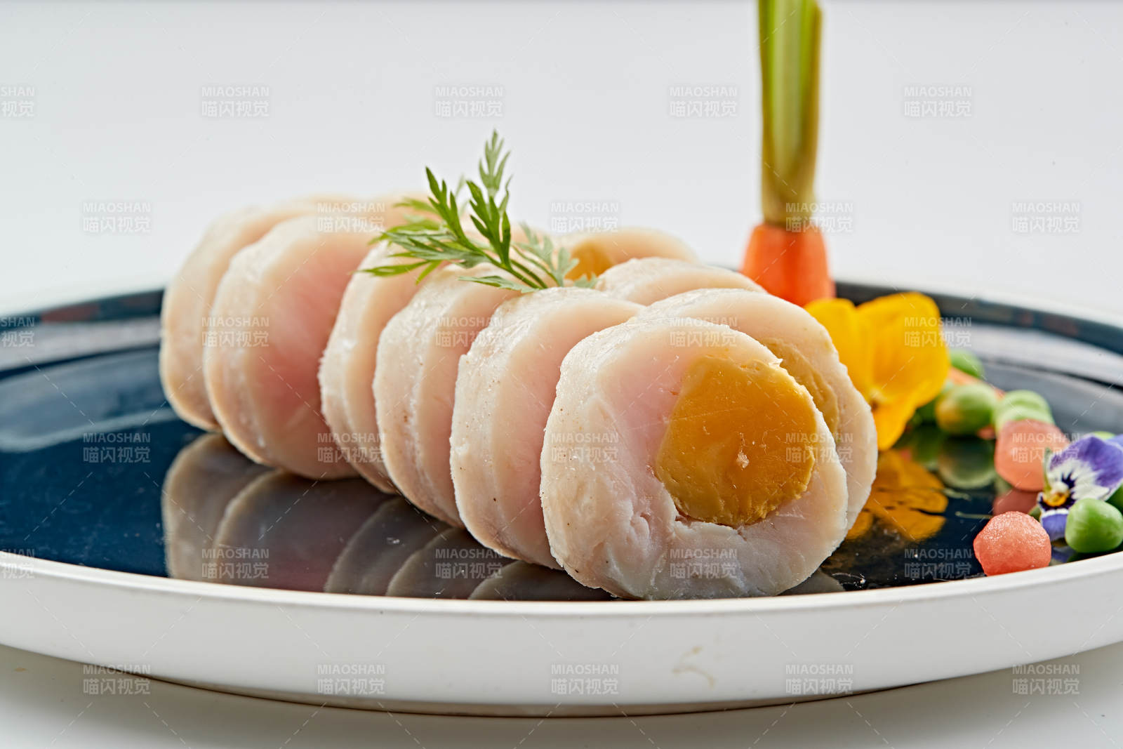 蓝釉瓷盘装的墨鱼泥压咸蛋黄切片图片