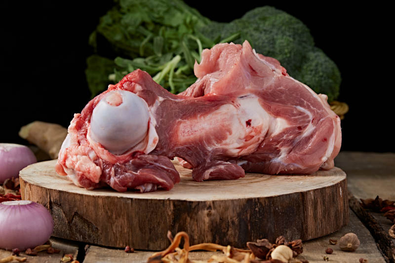 白色背景下的生鲜猪棒骨图片