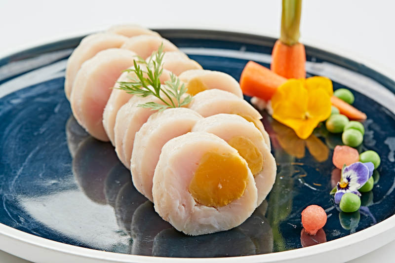 蓝釉瓷盘装的墨鱼泥压咸蛋黄切片图片