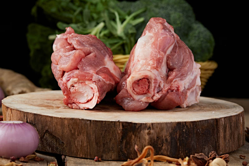 白色背景下的生鲜猪棒骨图片