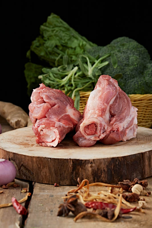 白色背景下的生鲜猪棒骨图片