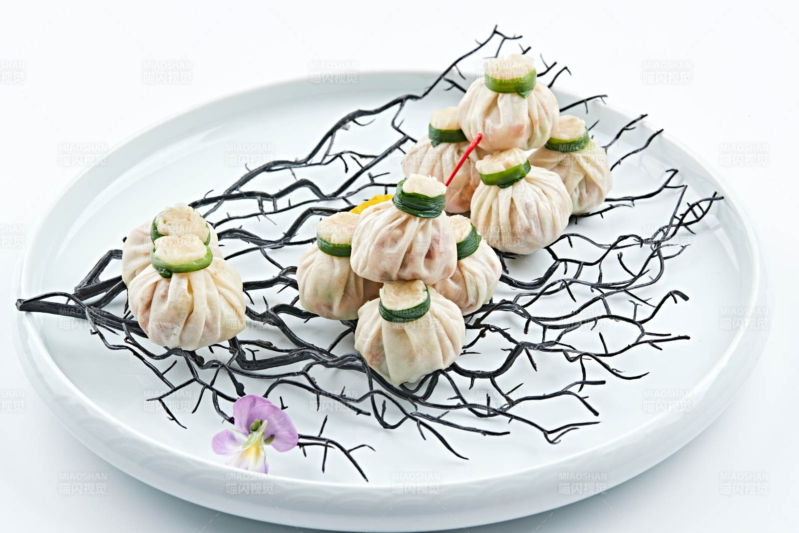 青色瓷盘装的精美蒸小福袋图片