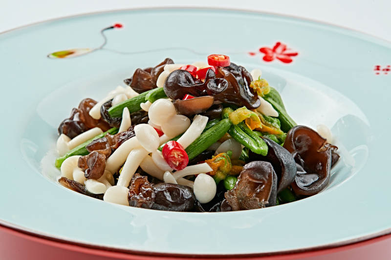 青色瓷盘装的瓜苗拌杂菌图片