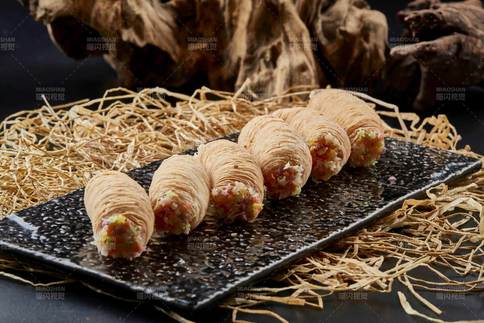 黑色瓷盘装的香酥奶黄蛋酥图片