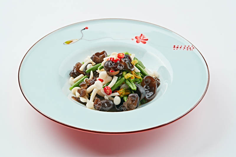 青色瓷盘装的瓜苗拌杂菌图片