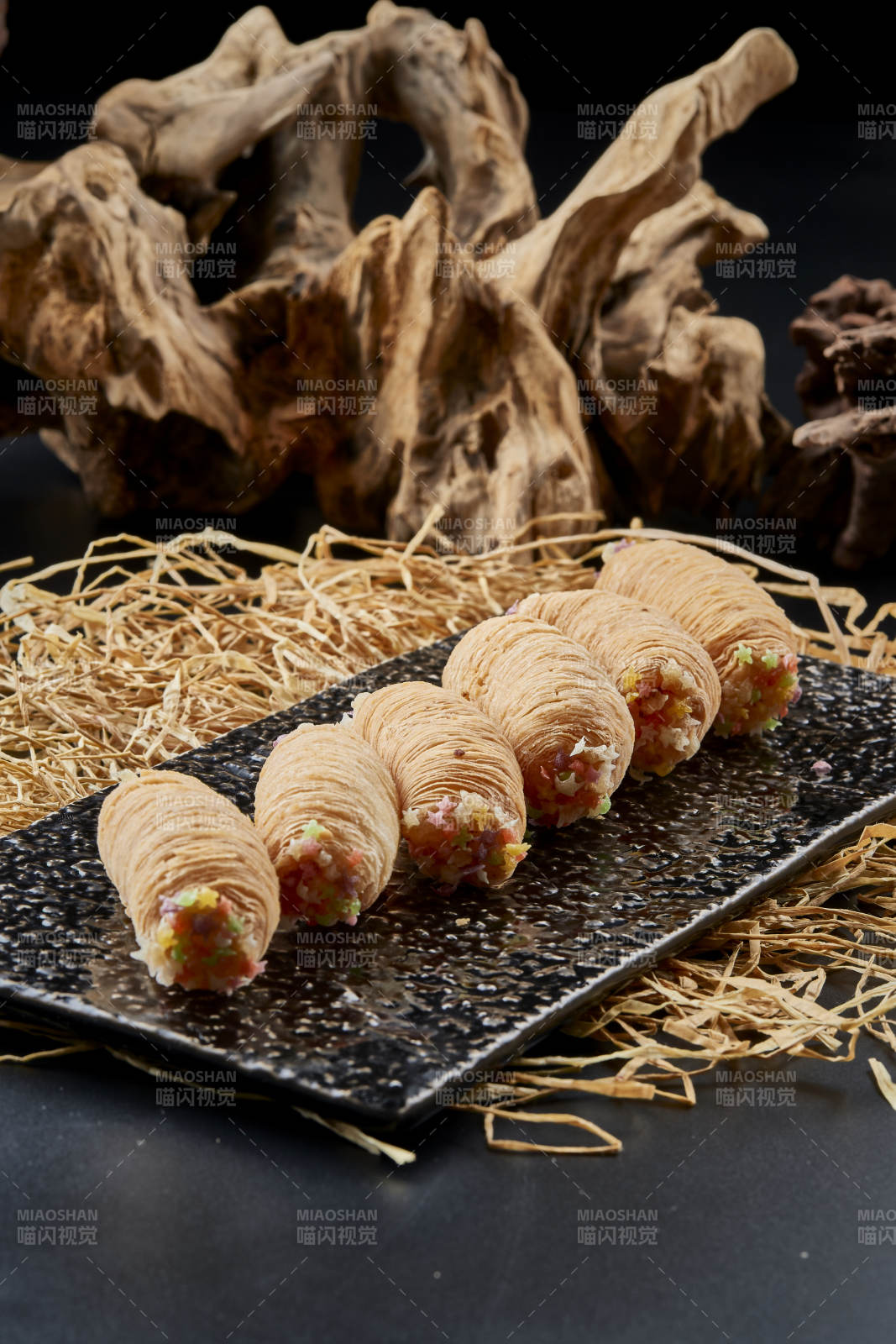 黑色瓷盘装的香酥奶黄蛋酥图片