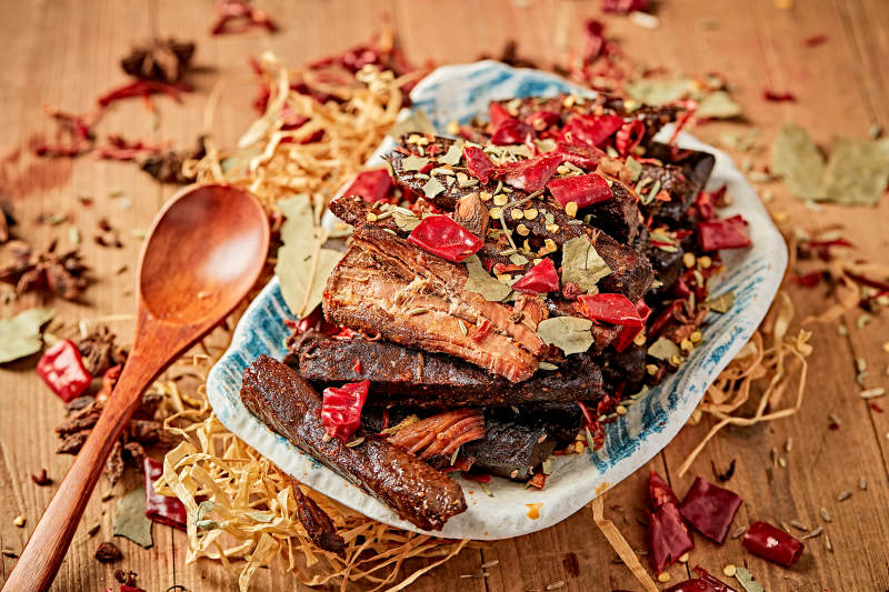 木质背景上摆放的自然香辣牛筋肉图片