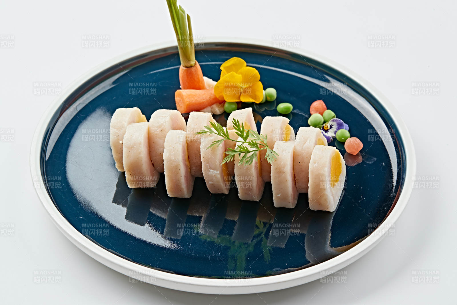 蓝釉瓷盘装的墨鱼泥压咸蛋黄切片图片