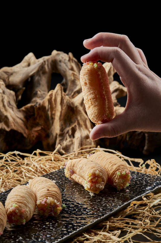 黑色瓷盘装的香酥奶黄蛋酥图片