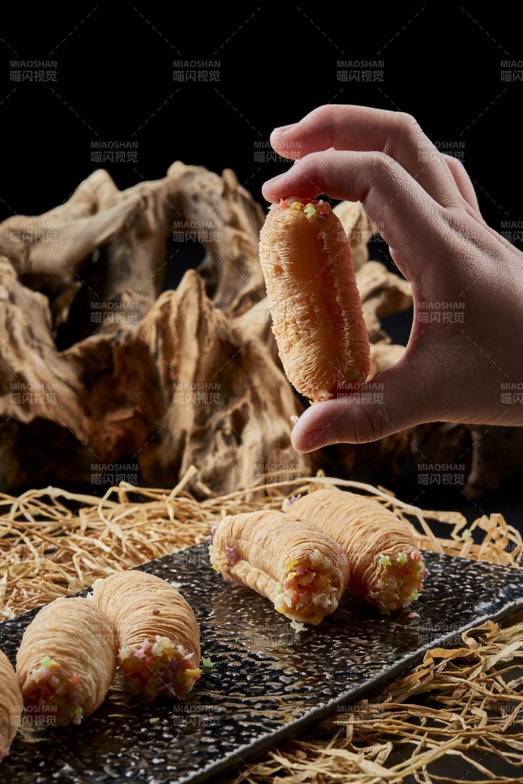 黑色瓷盘装的香酥奶黄蛋酥图片