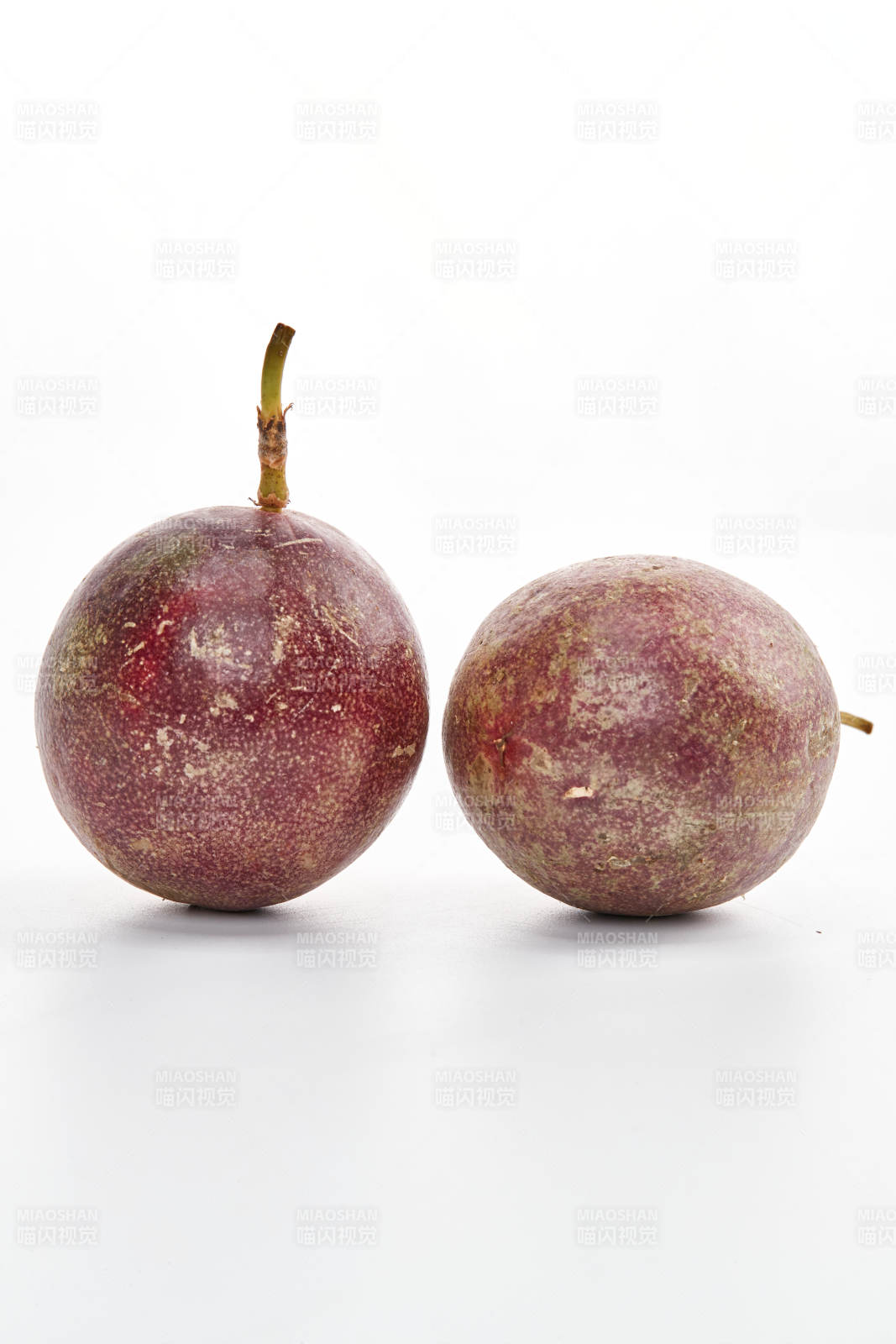 白色背景上摆放的新鲜百香果图片