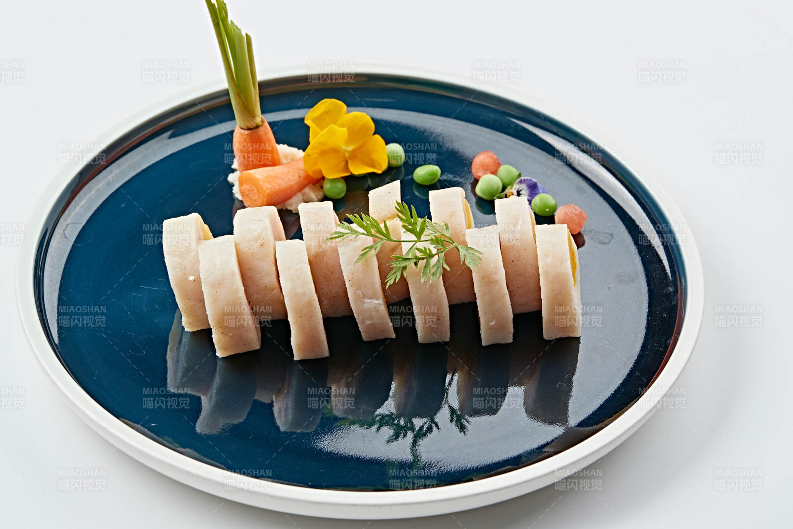 蓝釉瓷盘装的墨鱼泥压咸蛋黄切片图片