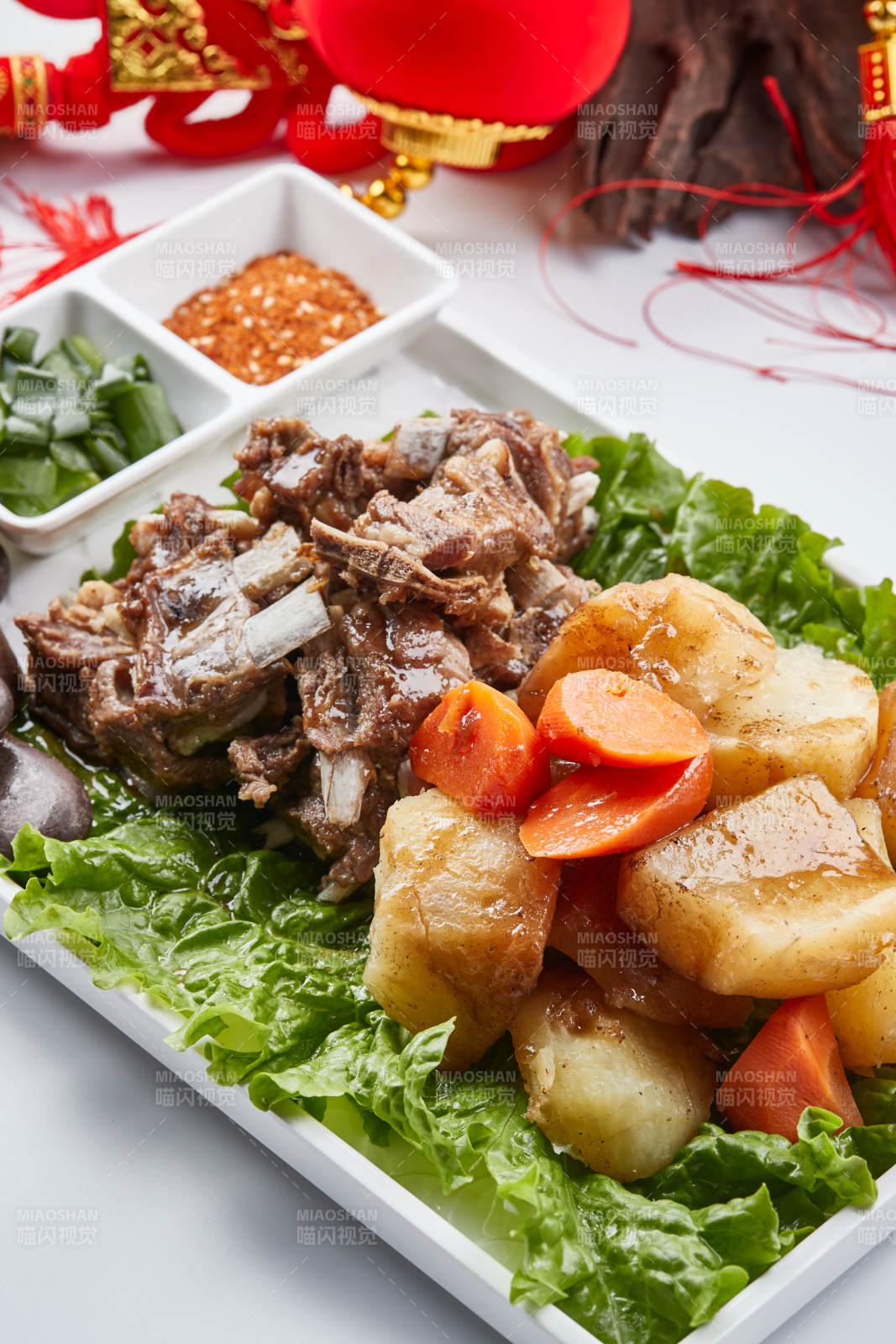 白色瓷盘装的胡萝卜土豆炖羊排图片