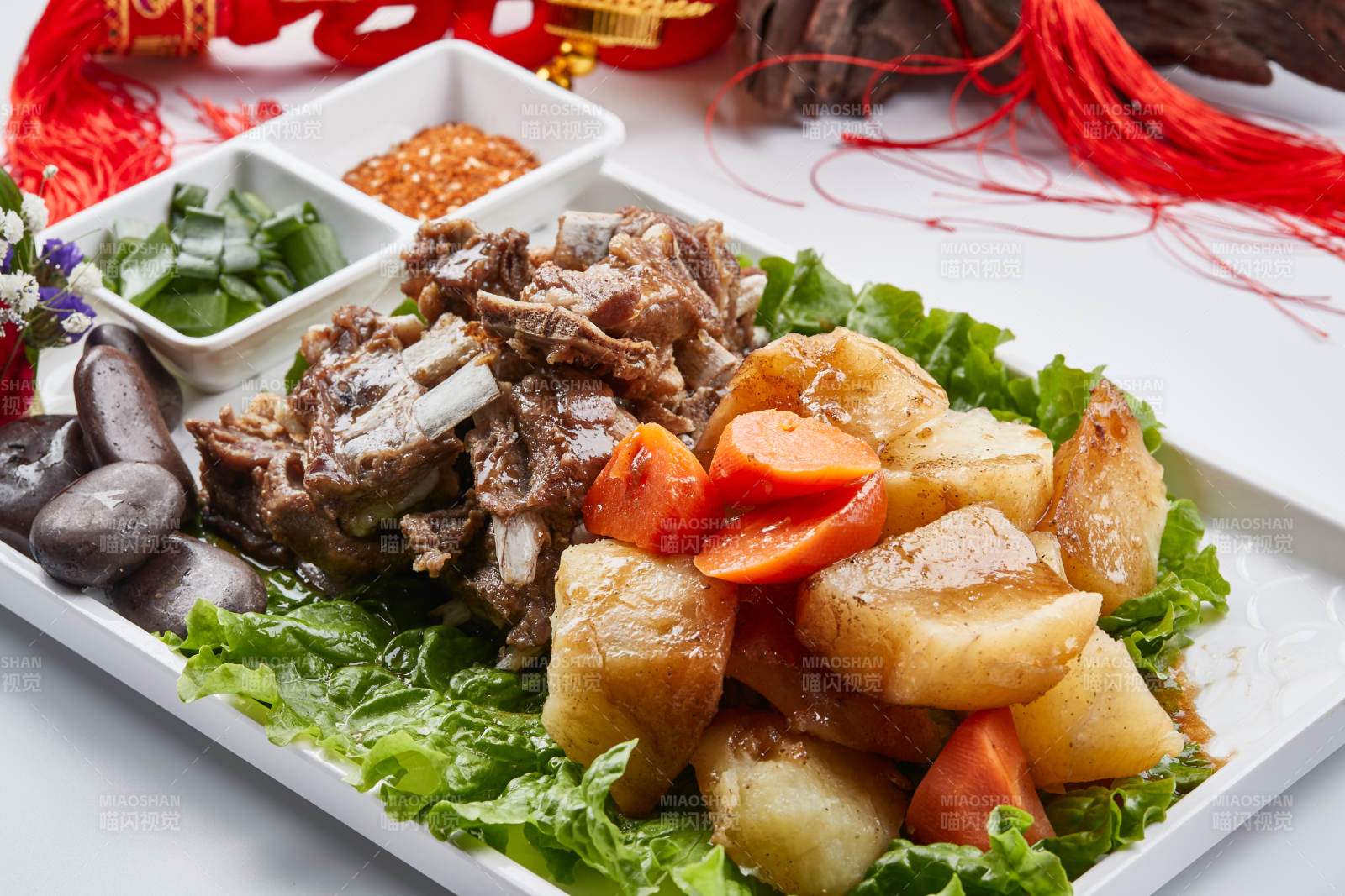 白色瓷盘装的胡萝卜土豆炖羊排图片