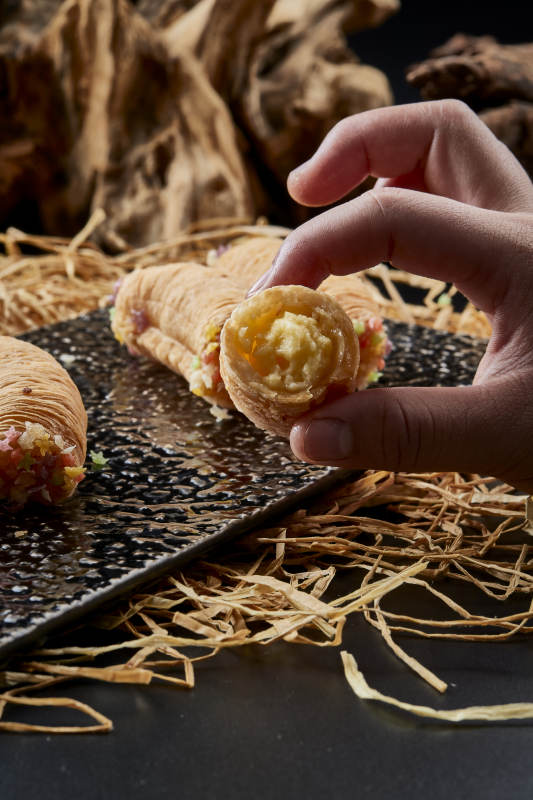 黑色瓷盘装的香酥奶黄蛋酥图片