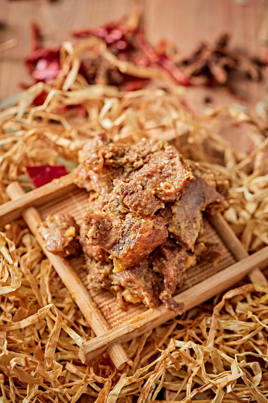 木质背景上摆放的自然香辣牛筋肉图片