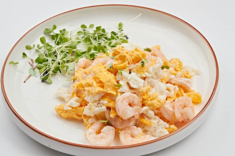白色瓷盘装的香椿苗虾仁炒泉水蛋图片