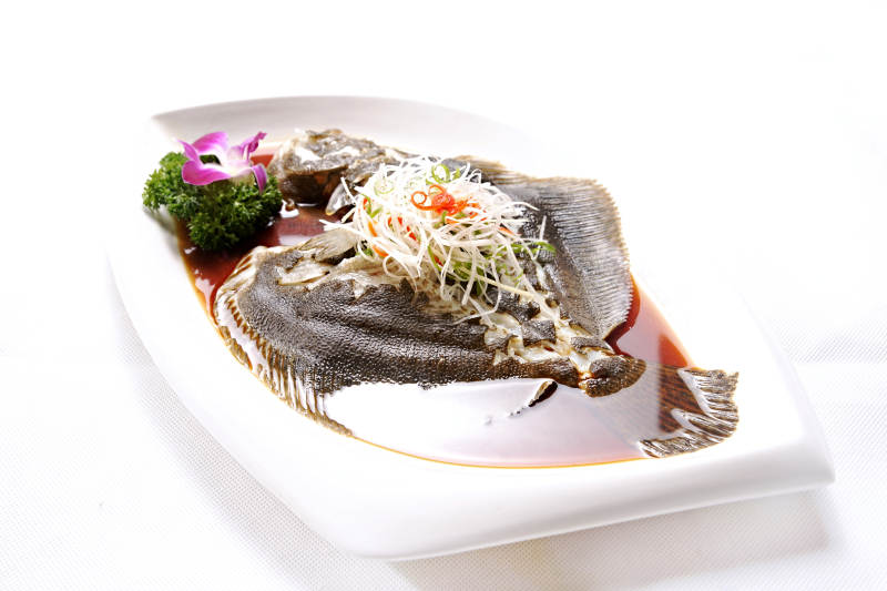 椭圆白瓷盘装的清蒸多宝鱼图片