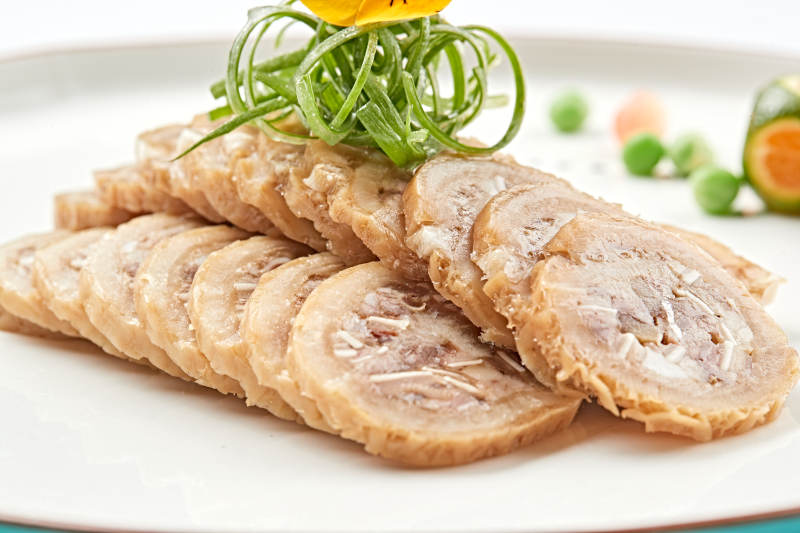 白色瓷盘装的鱿鱼压猪肚切片图片