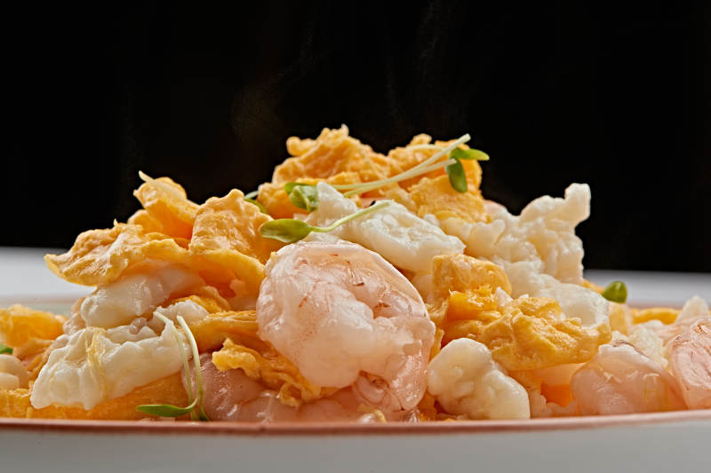 白色瓷盘装的香椿苗虾仁炒泉水蛋图片