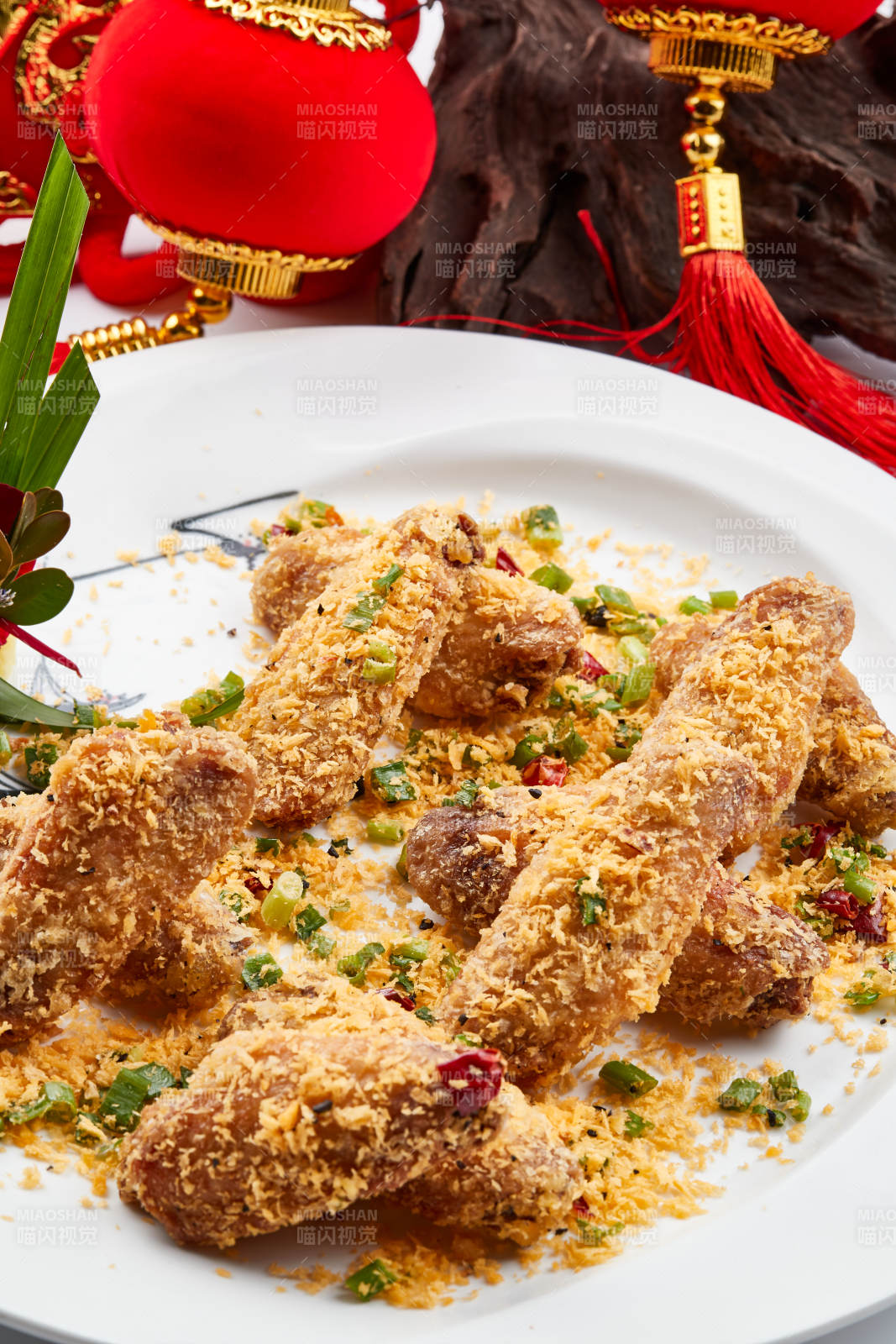 白色瓷盘装的的香炸避风塘鸡翅图片