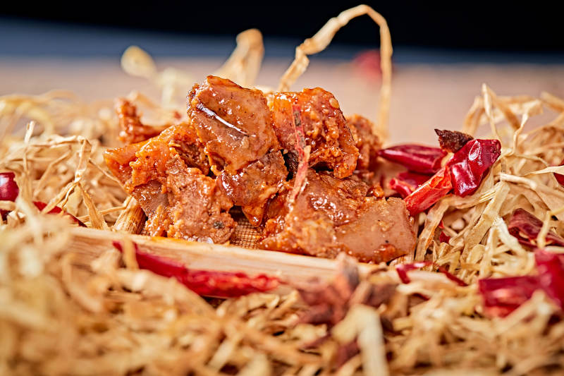 木质背景上摆放的自然香辣牛筋肉图片