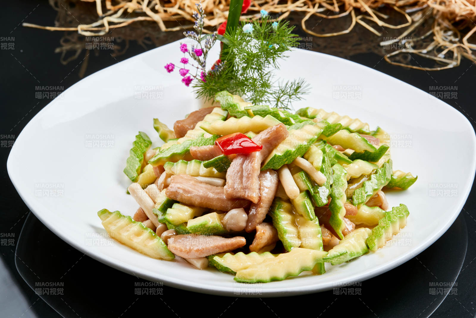 白色瓷盘装的西葫芦小炒猪颈肉图片