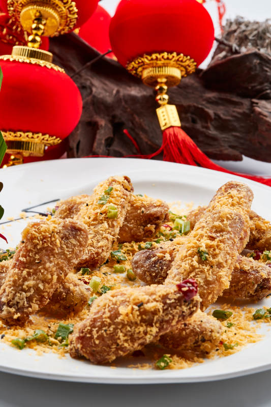 白色瓷盘装的的香炸避风塘鸡翅图片