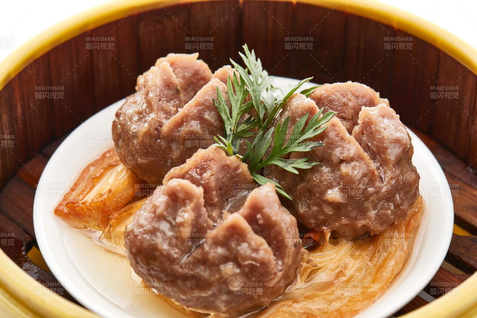 白色背景上精美竹笼屉装的开花牛肉球图片