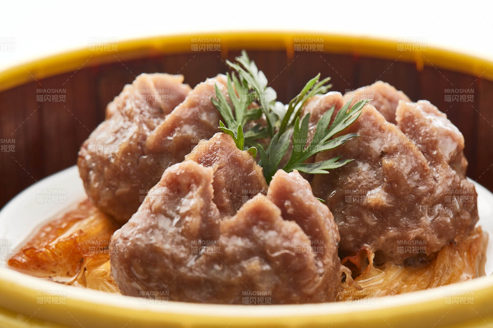 白色背景上精美竹笼屉装的开花牛肉球图片