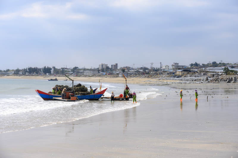 渔舟靠岸 沙滩人影图片