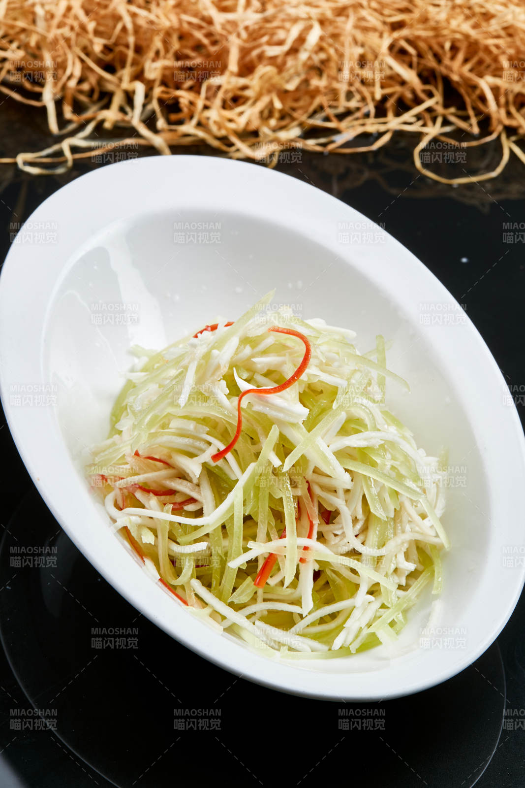 白色瓷盘装的巧拌双丝西芹丝土豆丝图片