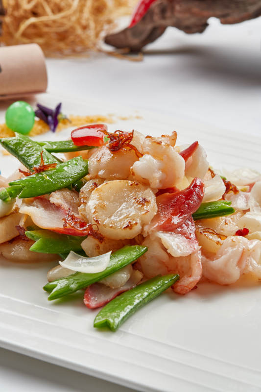 白色瓷盘装的的粤式小炒蜜豆炒海鲜图片