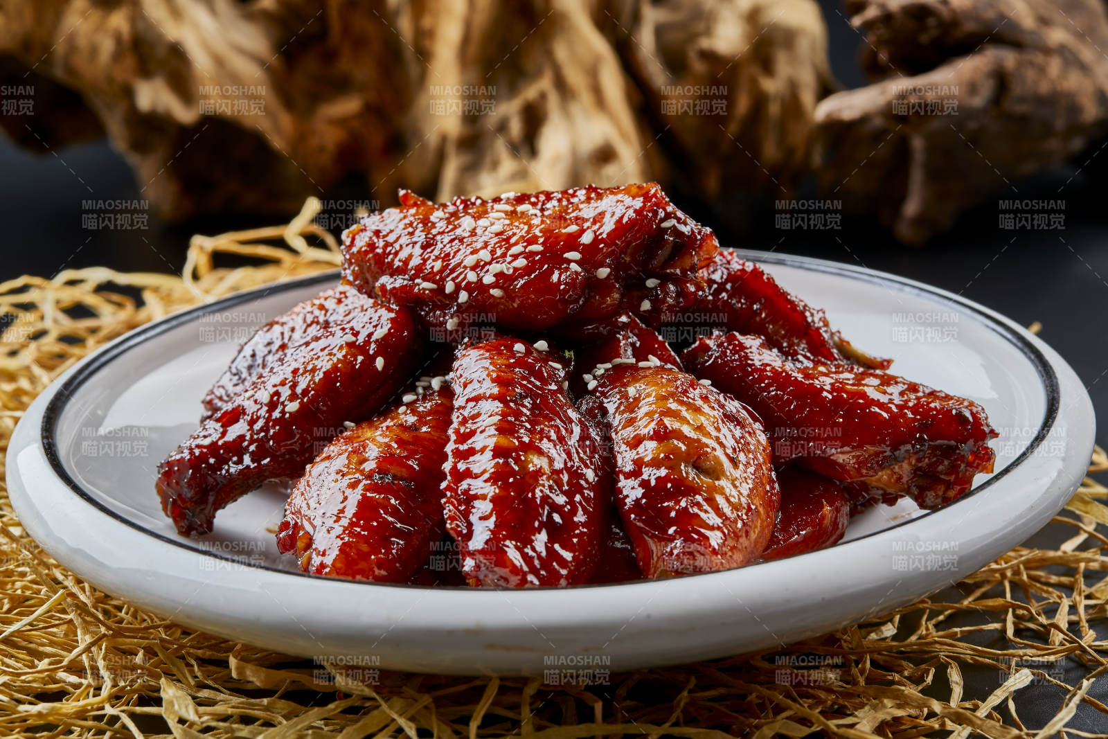 圆形瓷盘装的秘制酱烧鸡翅中图片