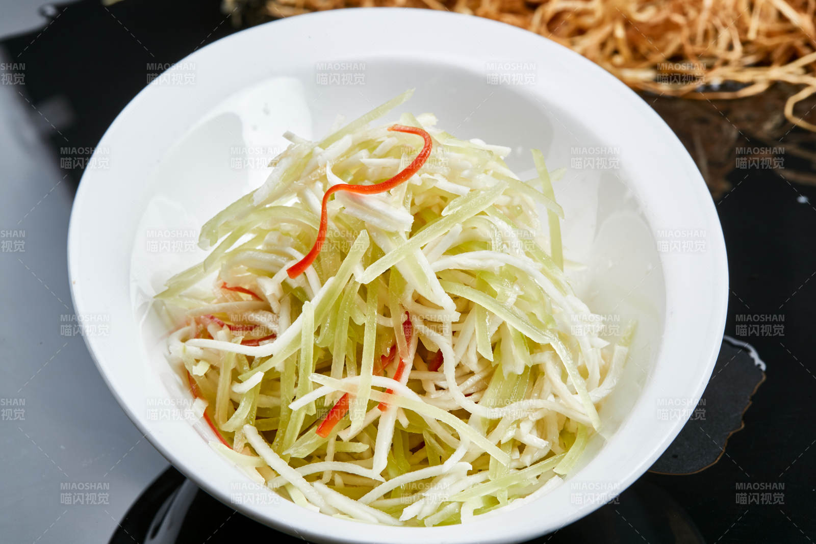 白色瓷盘装的巧拌双丝西芹丝土豆丝图片