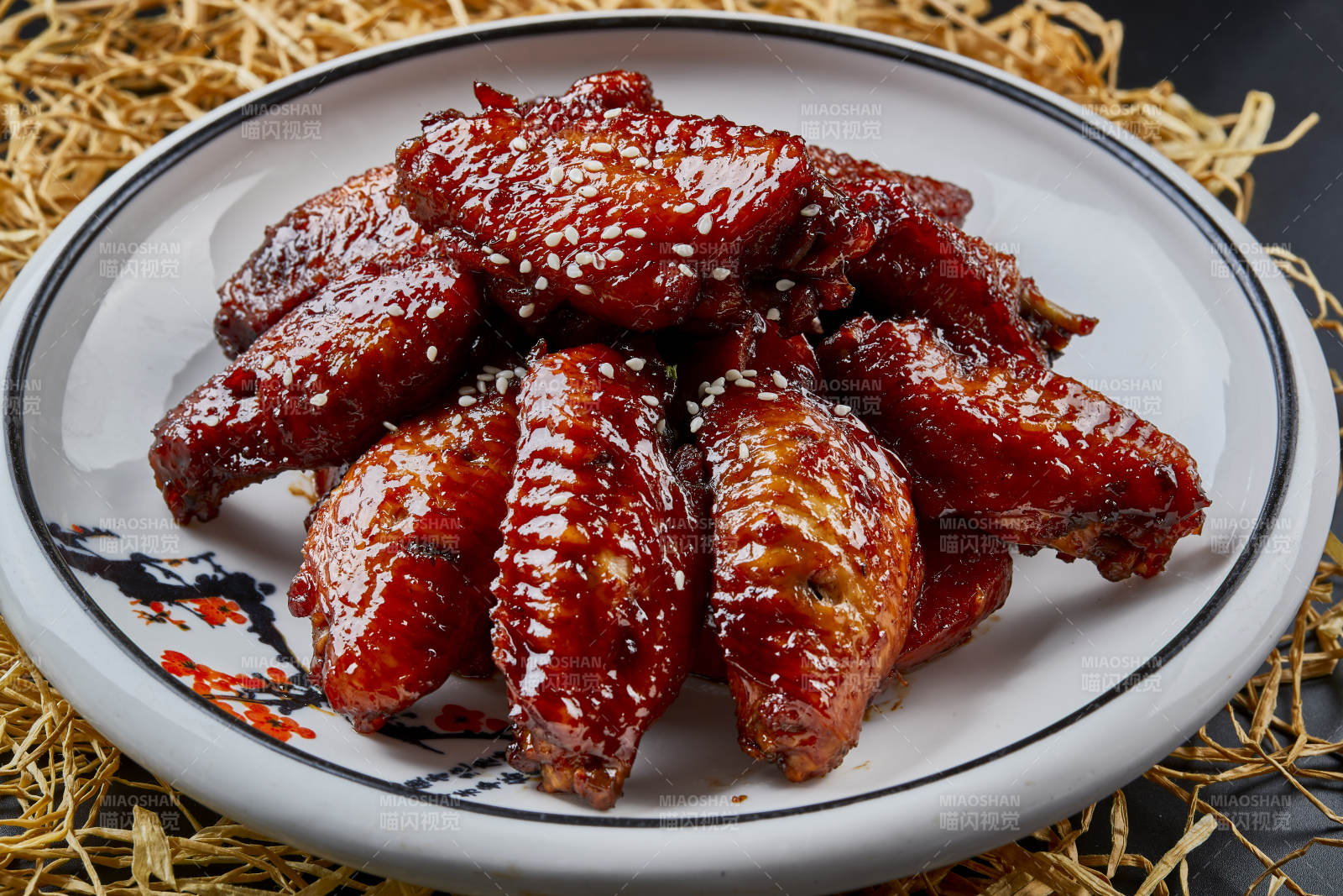 圆形瓷盘装的秘制酱烧鸡翅中图片