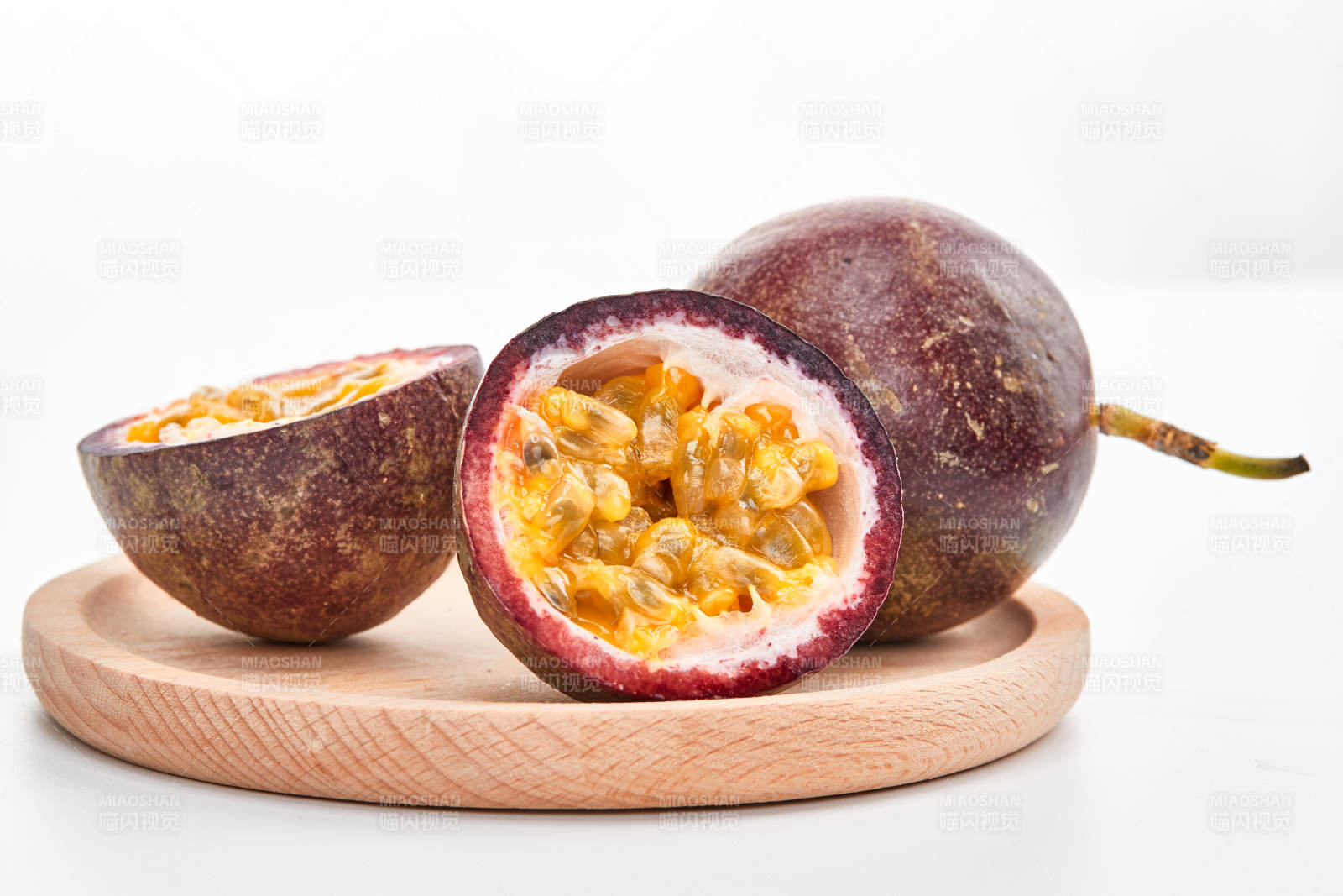 白色背景上摆放的新鲜百香果图片