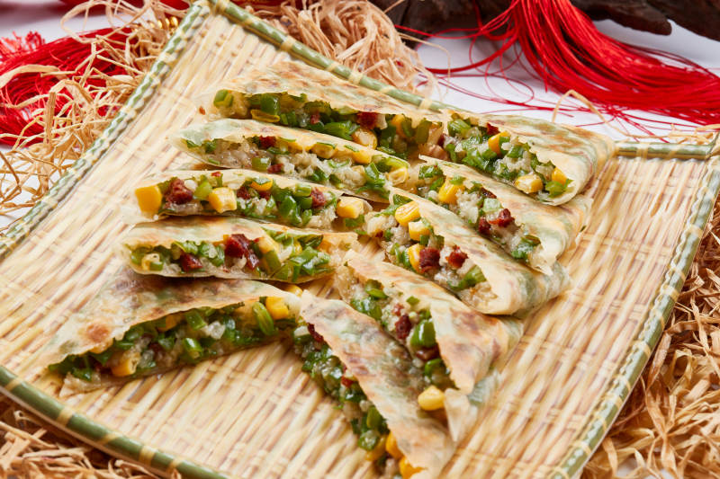 竹子笸箩装的江米牛肉玉米野菜饼图片