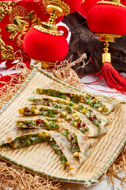 竹子笸箩装的江米牛肉玉米野菜饼图片