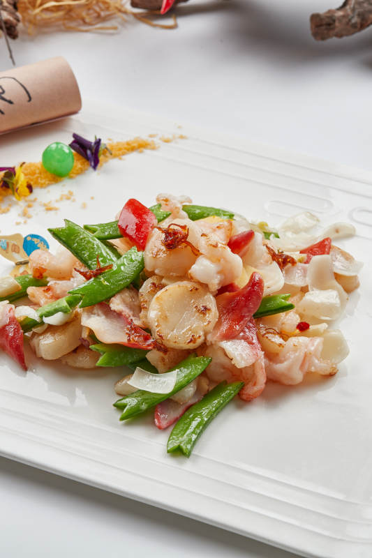 白色瓷盘装的的粤式小炒蜜豆炒海鲜图片