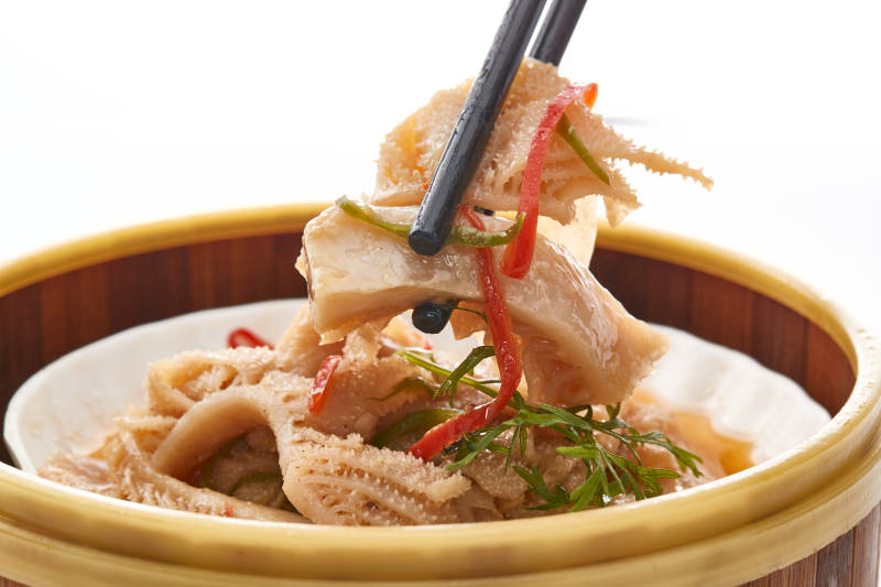 白色背景上精美竹笼屉装的港式蒸肚丝图片