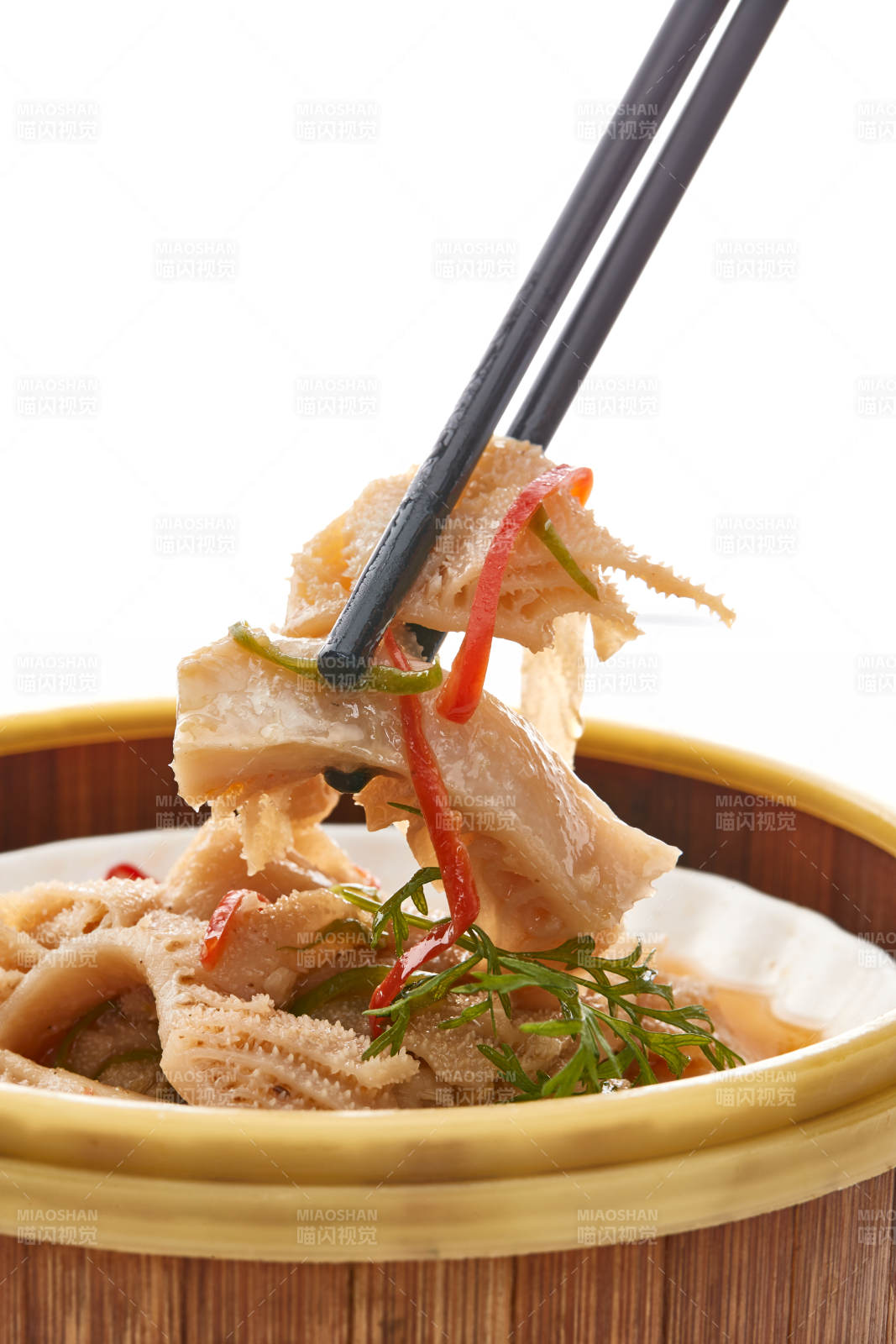 白色背景上精美竹笼屉装的港式蒸肚丝图片