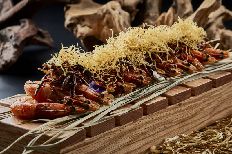 木质餐具上摆放的薯丝梅菜焗大明虾图片