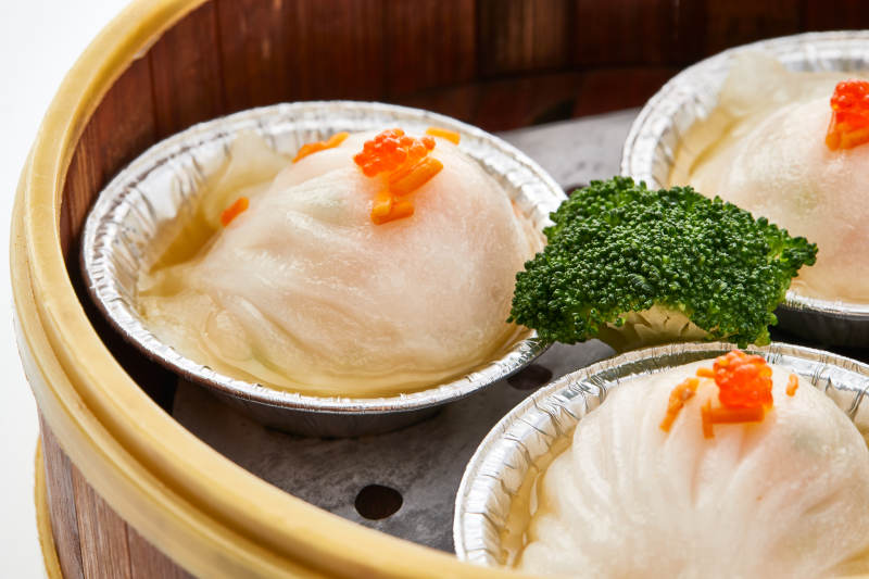 白色背景下精美竹笼屉装的港式茶餐蒸虾饺图片