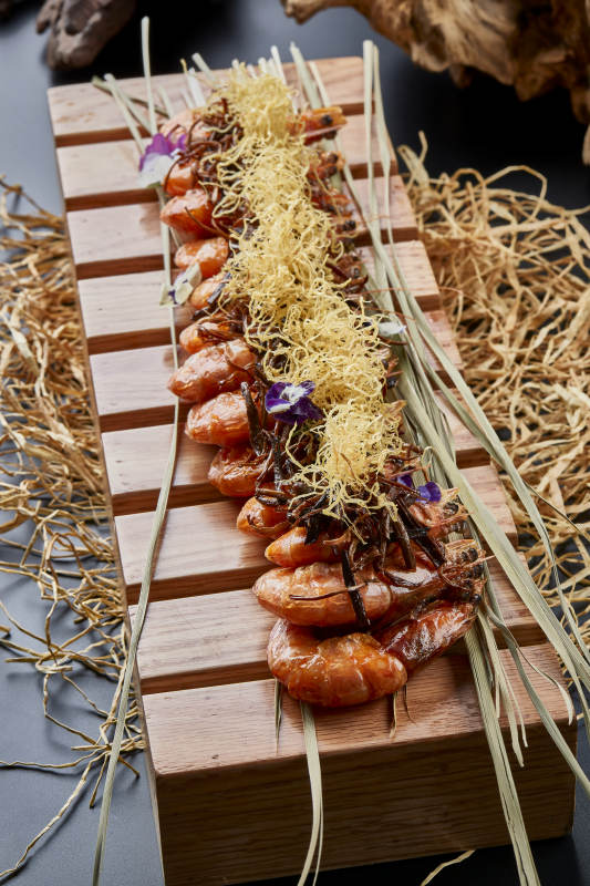 木质餐具上摆放的薯丝梅菜焗大明虾图片