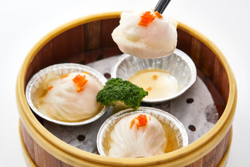 白色背景下精美竹笼屉装的港式茶餐蒸虾饺图片