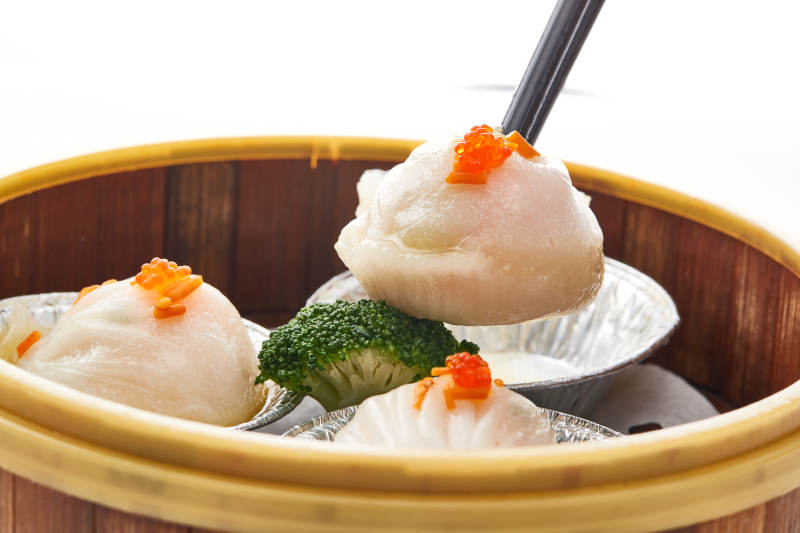 白色背景下精美竹笼屉装的港式茶餐蒸虾饺图片